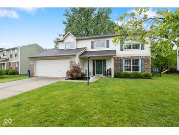 Charming two-story home with attached two-car garage, lush lawn, brick accents and manicured landscaping at 12524 Trophy Dr, Fishers, IN 46038