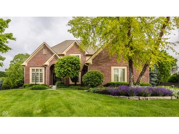 Charming brick home featuring a well-manicured lawn and professionally landscaped front yard at 12539 Pebblepointe Pass, Carmel, IN 46033