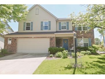 Charming two-story home with a brick facade, attached garage, and well-manicured lawn at 12677 Honors Dr, Carmel, IN 46033