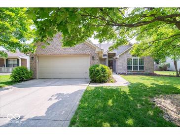 Charming brick home with a well-manicured lawn, mature trees, and an attached two-car garage at 13911 Naples Dr, Fishers, IN 46038