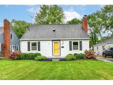 Charming single-story home featuring a brick chimney, mature landscaping and a bright yellow front door at 2526 Dell Zell Dr, Indianapolis, IN 46220