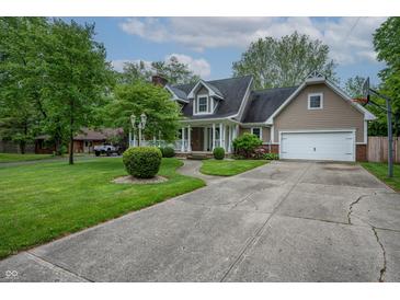 Charming home boasts a well-manicured lawn, inviting porch, and an attached two-car garage at 4013 Hillendale Dr, Greenwood, IN 46142