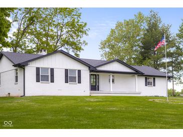 Charming single-story home with a sprawling front lawn, a covered porch and a American flag at 4605 S 150 W, Columbus, IN 47201