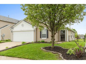 Charming single-Gathering home with a well-manicured lawn and a mature shade tree in the front yard at 671 Greenway St, Greenwood, IN 46143