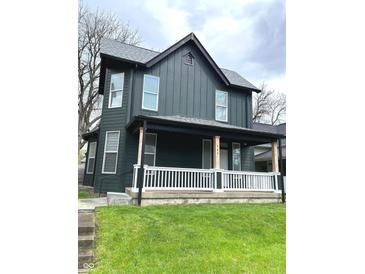 Inviting two-story home with a charming front porch and well-maintained lawn at 909 N Temple Ave, Indianapolis, IN 46201