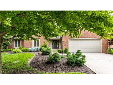 Charming brick home featuring an attached garage, beautifully landscaped front yard, and a covered entrance at 9445 Moorings Blvd, Indianapolis, IN 46256