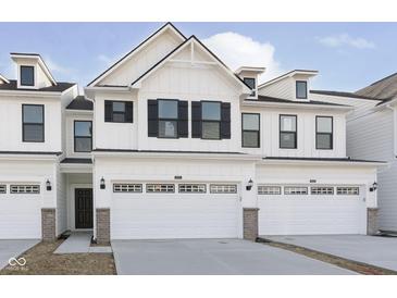 New construction townhome featuring white siding, black shutters, and attached two car garage at 9741 Oleander Dr, Fishers, IN 46250