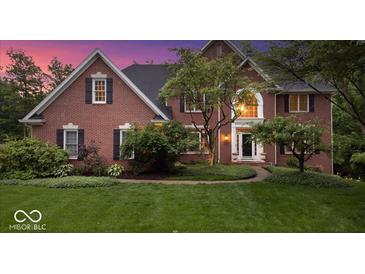 Charming red brick home with manicured lawn and lush landscaping at 11227 Woods Bay Ln, Indianapolis, IN 46236