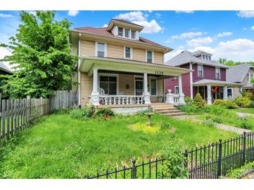 Charming two-story home featuring a welcoming front porch, well-maintained lawn, and classic architectural details at 1138 N Oxford St, Indianapolis, IN 46201