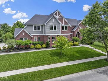 Beautiful two-story home featuring a manicured lawn, brick facade, and mature landscaping at 11984 Talnuck Cir, Fishers, IN 46037