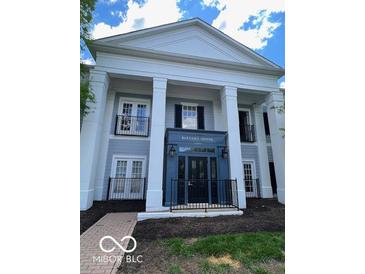 Welcoming building entrance with beautiful architectural details and manicured landscaping at 12853 Tradd St # 2B, Carmel, IN 46032