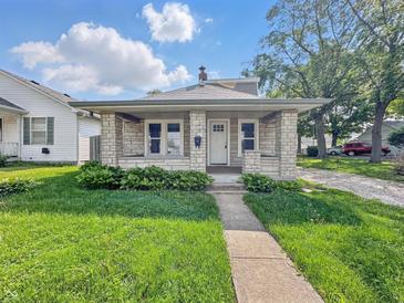 Charming single-story home features stone accents, manicured lawn, and a welcoming front porch at 145 S 7Th Ave, Beech Grove, IN 46107