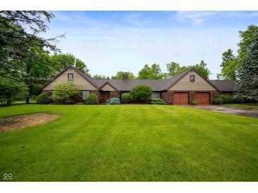 Ranch home with brick facade, attached garage and lush green lawn at 2411 N County Road 500 W, Muncie, IN 47304