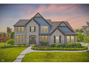 Beautiful two-story home featuring a well-manicured lawn and a combination of brick and siding at 2485 Alexandra Dr, Carmel, IN 46074