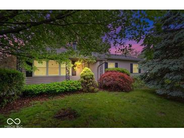 Charming single-story home featuring a lush front yard with mature trees and colorful landscaping at 3801 N Vernon Dr, Muncie, IN 47304