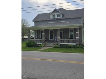 Charming two-story home featuring a welcoming front porch with stone pillars and a landscaped yard at 4303 W County Road 200 S Rd, Danville, IN 46122
