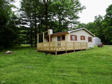 The home offers a large, inviting wooden deck surrounded by lush green landscaping and mature trees at 4675 N Herbemont Rd, Martinsville, IN 46151