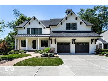 Charming two-story home featuring a black roof, white painted brick, and a two car garage at 6450 Holliday E Dr, Indianapolis, IN 46260