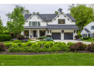 Charming two-story white home featuring a well-manicured lawn and a two-car garage at 6450 Holliday E Dr, Indianapolis, IN 46260