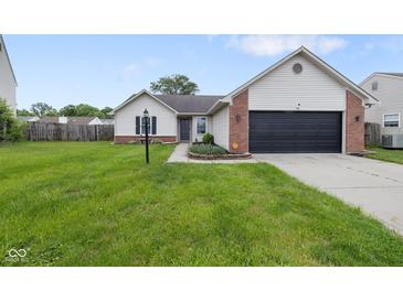 Charming single-story home with a well-maintained lawn and attached two car garage at 7319 Jackie Ct, Indianapolis, IN 46221