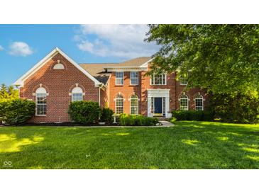Charming brick home with a well-manicured lawn, mature trees and a beautiful facade at 734 Richland Way, Westfield, IN 46074