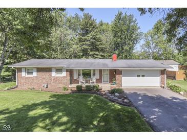 Charming brick ranch-style home with an attached garage, landscaped yard, and mature trees at 8246 S Franklin Rd, Indianapolis, IN 46259