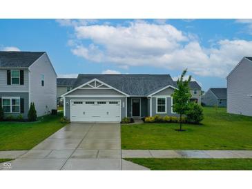 Charming single-story home featuring a two-car garage and a well-manicured front lawn at 9829 Hulton Rd, Pendleton, IN 46064