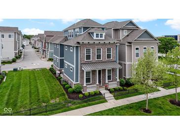 Beautiful two-story home with brick and siding, manicured lawn, and black metal fence at 13048 Minden Dr, Fishers, IN 46037