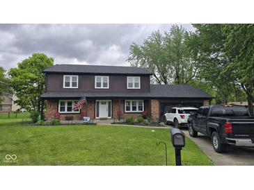 Charming two-story home with brick and wood facade, a well-kept lawn, and an attached garage at 131 Creek View Ct, Greenfield, IN 46140