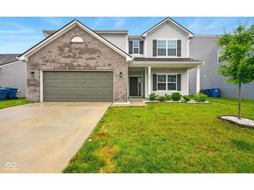 Charming two-story home with a gray brick facade, lush green lawn, and attached two-car garage at 1454 Silver Pine Ln, Sheridan, IN 46069