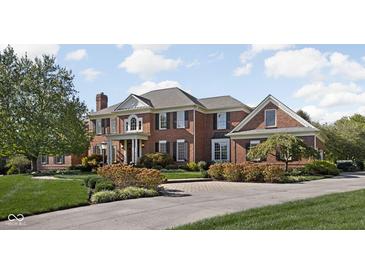 Elegant brick home featuring manicured landscaping and a circular driveway at 24 Shannon Rd, Zionsville, IN 46077