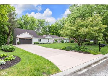 Charming single-story home featuring a manicured lawn, long driveway, and inviting curb appeal at 445 W 63Rd St, Indianapolis, IN 46260