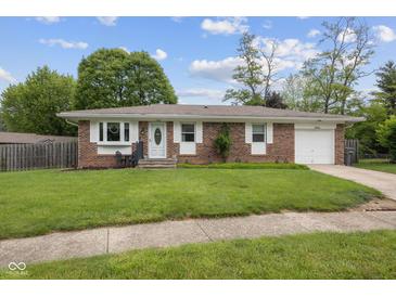 Charming brick home with a well-manicured lawn, attached garage, and inviting front entrance at 5326 Brazos Dr, Indianapolis, IN 46237