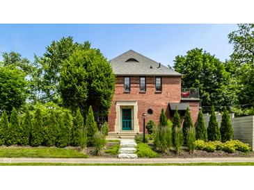 Charming brick home with a well-manicured lawn and stone walkway leading to a green front door at 5401 N New Jersey St, Indianapolis, IN 46220