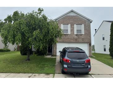 Charming two-story brick home with a well-manicured front yard and attached two-car garage at 5502 Floating Leaf Dr, Indianapolis, IN 46237