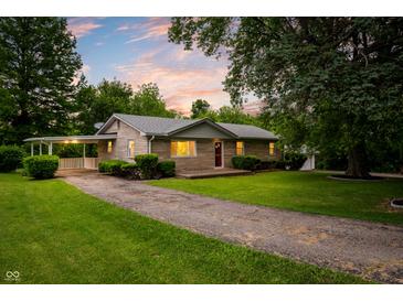 Charming one-story home with well-maintained lawn, brick facade, covered car port, and picturesque curb appeal at 7482 W Us Highway 40, Indianapolis, IN 46229