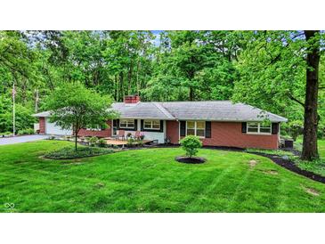 Charming brick ranch with well-maintained landscaping and inviting curb appeal in a serene, wooded setting at 8641 Cholla Rd, Indianapolis, IN 46240