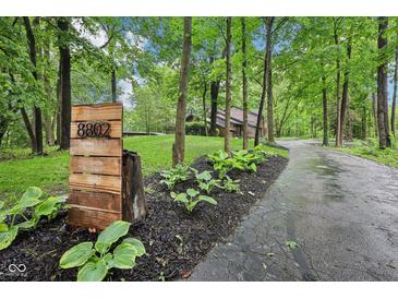 Long driveway leading to home, address displayed on wooden placard, lined with mulch and foliage at 8802 W 86Th St, Indianapolis, IN 46278