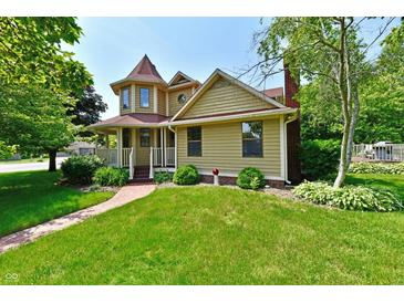 Charming two-story home with a turret, lush green lawn, and a welcoming brick pathway at 1010 Lakewood N Dr, Brownsburg, IN 46112