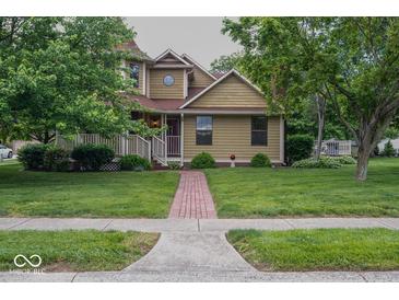 Charming two-story home with a well-manicured front yard, mature trees, and inviting front porch at 1010 Lakewood N Dr, Brownsburg, IN 46112