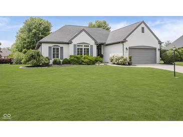 Charming single-story home featuring a well-manicured lawn and a two-car garage, enhancing curb appeal at 10510 Inverness Ct, Fishers, IN 46037