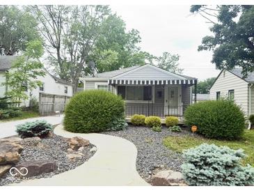 Charming home featuring an inviting walkway, awning, and well-maintained landscaping at 1844 N Riley Ave, Indianapolis, IN 46218