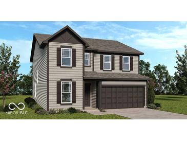 Charming two-story home featuring a two-car garage, complemented by well-maintained landscaping at 1914 White Oak Dr, Shelbyville, IN 46176