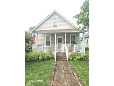 Charming home featuring a cozy front porch, a well-manicured lawn, and inviting curb appeal at 208 E Madison E St, Alexandria, IN 46001