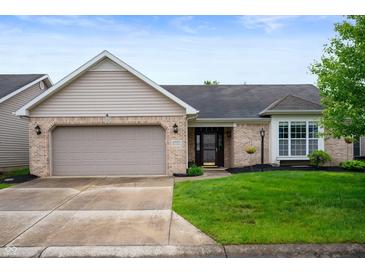 Charming single-Gathering home featuring a brick facade, attached garage, and well-manicured lawn at 2717 W Long Meadow Ln, Muncie, IN 47304