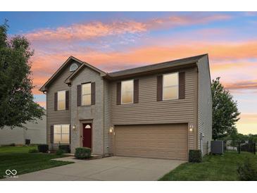 Charming two-story home with a brick and vinyl exterior and a two-car attached garage at 764 Port Dr, Avon, IN 46123
