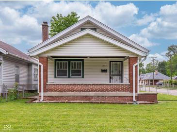 Charming single-story home with a welcoming porch, brick accents and freshly mowed lawn at 1065 36Th St, Indianapolis, IN 46208