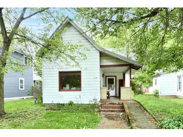 Charming home featuring an inviting front porch, complemented by mature trees, and an access ramp at 1106 W 4Th St, Anderson, IN 46016
