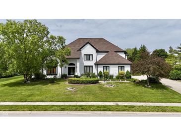 Charming two-story home with a lush green lawn, mature trees, and a welcoming front entrance at 14020 Brookstone Dr, Carmel, IN 46032