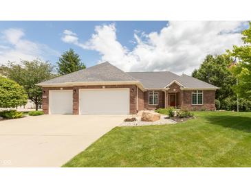 Charming brick home with a manicured lawn, three car garage, and stone landscaping at 1589 Belleflower Ct, Avon, IN 46123